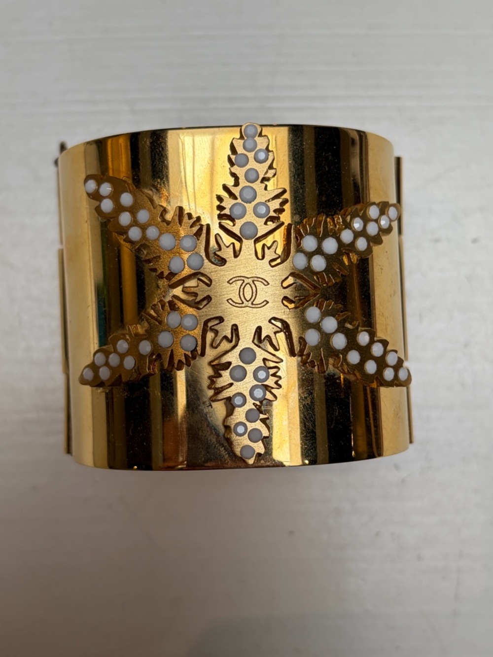 CHANEL Gold Toned Cuff with White Enamel Starburst Motif